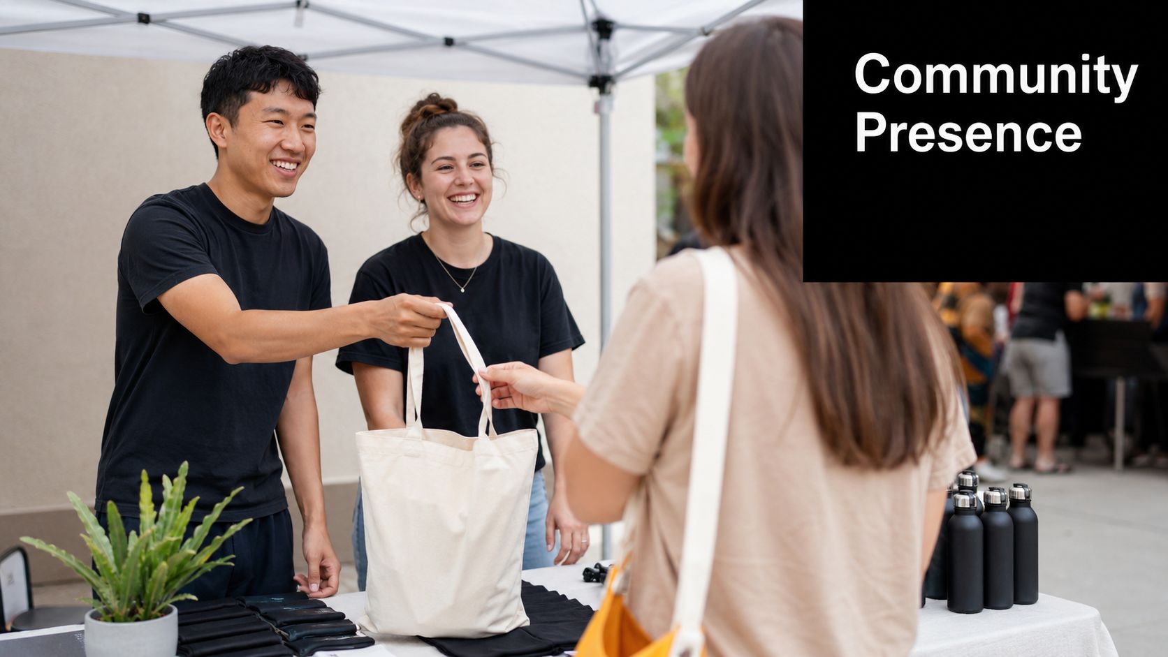 Friendly volunteers distributing tote bags to a community member at a vibrant outdoor public event table.